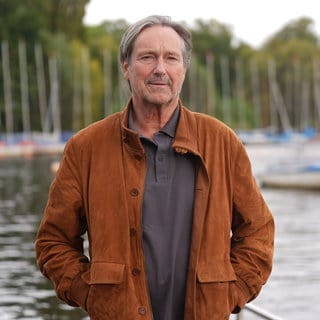 Schauspieler Helmut Zierl steht an der Außenalster am Bootsanleger des Restaurants Bobby Reich.