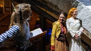 Stage Managerin der Bregenzer Festspiele, Sophie Louise Busch mit Katharina "Ännchen" Ruckgaber und Irina "Agathe" Simmes (v.l.n.r.) unter dem Bühnenbild zu "Der Freischütz".