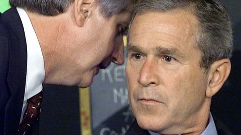 US-Präsident George W. Bush wird bei einer morgendlichen Vorleseveranstaltung an einer Schule von seinem Stabschef Andrew Card (l.) unterbrochen, kurz nachdem in Sarasota, Florida, die Nachricht von den Flugzeugabstürzen in New York City eingetroffen war.