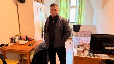 Ex-Häftling Ahmet Can steht in seinem Zimmer.
