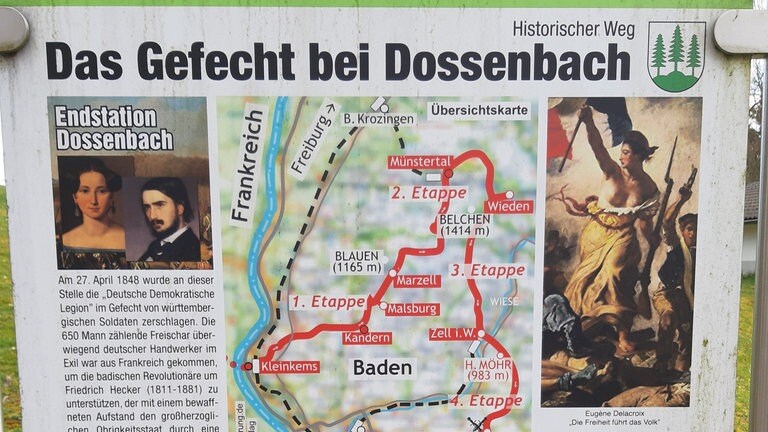 Badische Revolution 1848: Tafeln informieren über die "Deutsche Demokratische Legion", die am 27. April 1848  in Dossenbach geschlagen wird. Es war wohl eine eher armselige Unternehmung, kaum mehr als 800 bis 1.000 Mann meist linke Handwerker und Arbeiter. Anführer ist der Dichter Georg Herwegh. Er hat seine Frau Emma als Kundschafterin vorgeschickt, um mit Hecker Kontakt aufzunehmen. Aber es gelingt nicht, sich mit dessen Truppen zu vereinigen. 30 Männer sterben; 300 werden zu Gefangenen. Georg und Emma Herwegh fliehen.