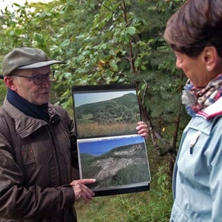 Armin Dieters zeigt Sonja Faber-Schrecklein Bilder vom Bergrutsch in Mössingen.
