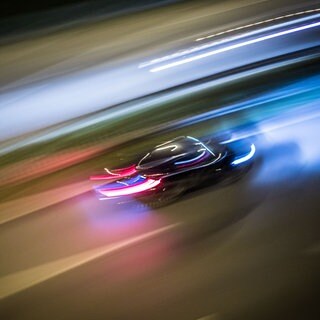 Ein Auto fährt sehr schnell auf einer Straße, die Scheinwerfer sind zu Lichtspuren verwischt - wie bei einem illegalen Autorennen, so wie das in Ludwigsburg
