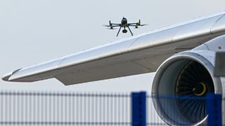 Eine Drohne der Polizei ist über einer Flugzeugtragfläche zu sehen