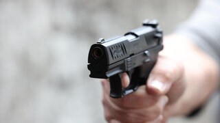 Eine Männerhand hält eine Schreckschusspistole (Symbolbild): In Frei-Weinheim hat ein Mann einem Gastwirt ins Gesicht geschossen, weil dieser ihm keine Getränke mehr ausschenken wollte. 