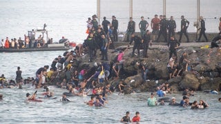 Migranten kommen nach dem Überqueren der Grenze in Ceuta an