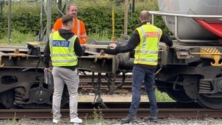 Bundespolizisten sichern Spuren an dem entgleisten Güterzug.