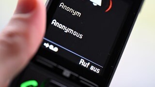 Ein Mann hält ein Festnetz-Telefon, auf dem ein anonymer Anruf eingeht (gestellte Szene). Laut neuer Kriminalstatistik gab es 2025 mehr betrügerische Anrufstraftaten in Baden-Württemberg
