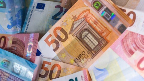 Mehrere Euro-Banknoten liegen auf einem Tisch.