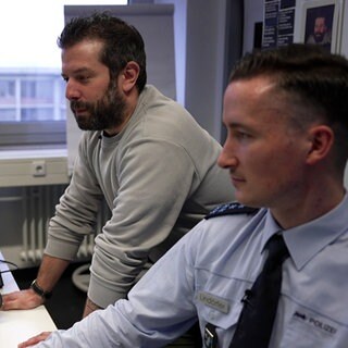 Zwei Polizisten arbeiten am Computer