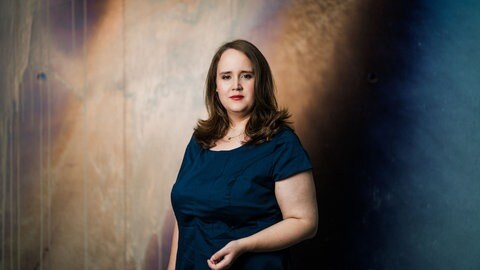 Ricarda Lang, Politikerin, steht seitlich gedreht und blickt in die Kamera.