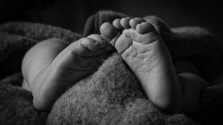Babyfüsse mit Decke schwarzweiß