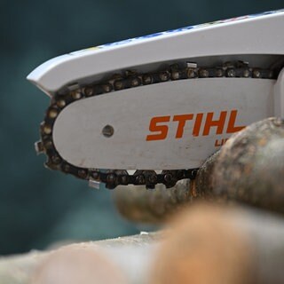 Das Logo des Motorsägen- und Gartengeräteherstellers Stihl ist an einer kleinen akkubterieben Säge angebracht, die Holz zersägt. Sägenhersteller Stihl aus Waiblingen hat der Politik mit Abwanderung gedroht, wenn Deutschland als Wirtschaftsstandort nicht wieder attraktiver gemacht wird.