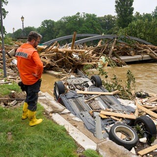 Ein Feuerwehrmann steht vor der zerstörten Landgrafenbrücke nach der Flutkatastrophe im Ahrtal. Unwetterereignisse wie dieses werden laut Experten durch den Klimawandel häufiger vorkommen.
