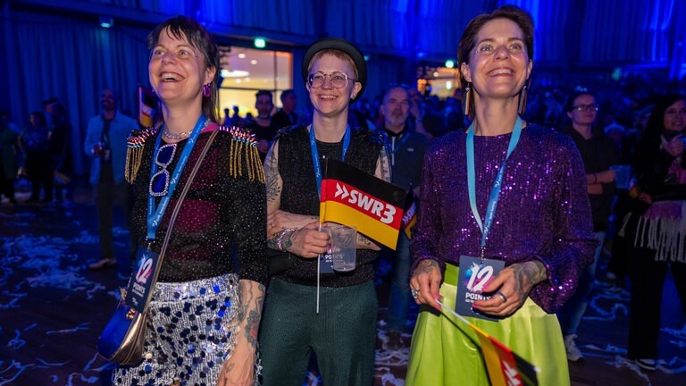 Drei weibliche fans feiern bei der ESC-Party in Karlsruhe 