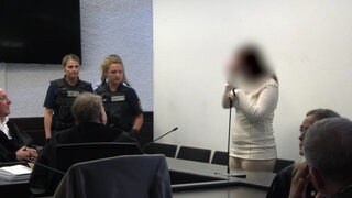 Eine junge Frau steht im Saal des Stuttgarter Landgerichts und erwartet ihr Urteil.