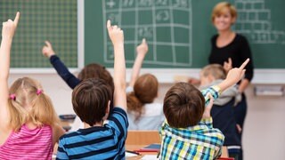 Viele Schüler melden sich in einem Klassenraum 