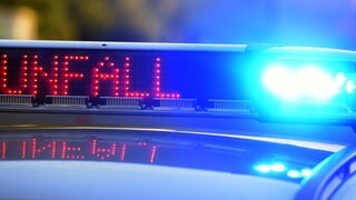 Auf einem Polizeifahrzeug warnt eine Leuchtschrift vor einer Unfallstelle