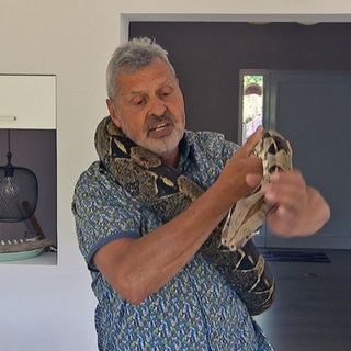 Andreas Alter hat seine Boa Constrictor um den Hals liegen