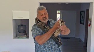 Andreas Alter hat seine Boa Constrictor um den Hals liegen