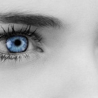Blaue Augen auf grauem Gesicht. Symbolfoto.