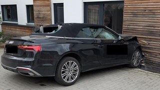 Ein beschädigter Audi vor einer eingedrückten Hauswand: Eine Frau in Edenkoben ist beim Parken mit ihrem Auto versehentlich gegen die Hauswand gefahren.