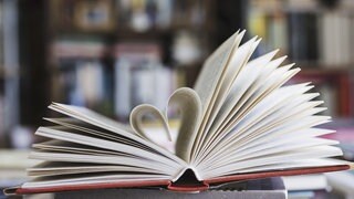 Ein Buch, dessen Seiten als Herz geformt sind.
