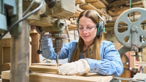 Junge Frau arbeitet in einer Schreinerei
