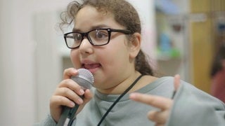 Mädchen singt in Mikrophon