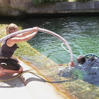Zwei Tierpfleger reinigen das Schwimmbecken der Seelöwen.