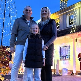 Familie Ripp vor ihrem weihnachtlich geschmückten Haus.