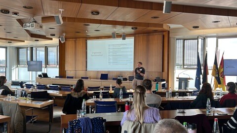 Careleaverin Jamie steht im Sitzungssaal des Landratsamts Böblingen und spricht von ihren Erfahrungen
