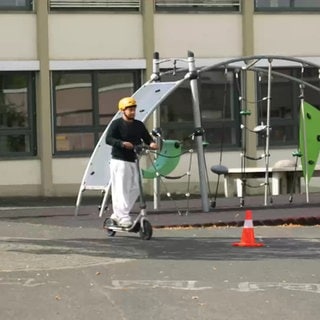 Schüler auf e-Scooter durchfährt Parkour