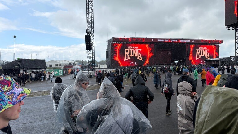 Rockfams in Regencapes auf Festivalgelände