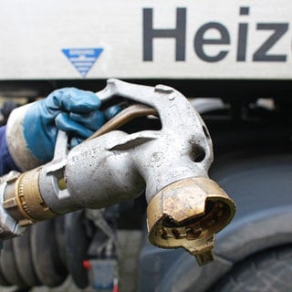 Mitarbeiter eines Heizöllieferanten bereitet die Befüllung des Tanks eines Hauses mit Heizöl vor. Der Ölpreis ist momentan sehr hoch. Die Verbraucher sind verunsichert. Lohnt es sich jetzt, Heizöl zu bestellen?