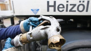 Mitarbeiter eines Heizöllieferanten bereitet die Befüllung des Tanks eines Hauses mit Heizöl vor. Der Ölpreis ist momentan sehr hoch. Die Verbraucher sind verunsichert. Lohnt es sich jetzt, Heizöl zu bestellen?