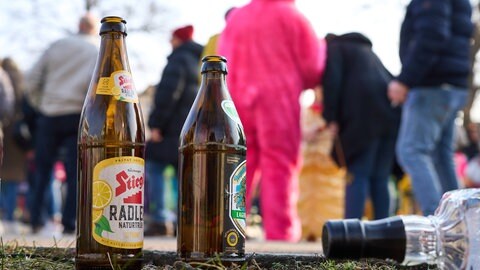 Leere Alkoholflaschen stehen am Straßenrand bei einer Fastnachtsveranstaltung. 