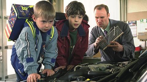 Sebastian und Albert krabbeln auf dem Motorraum eines Autos herum