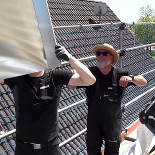 Zwei Spengler bei der Arbeit an einem Haus