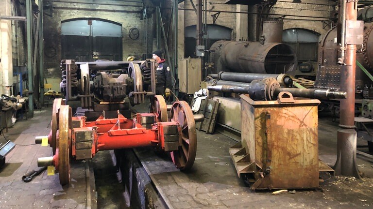 Die Drehgestelle werden in der MaLoWa Bahnwerkstatt zerlegt. Die Achsen sollen durch Pressen auf die karibische Spurweite von 750 mm gebracht werden. 