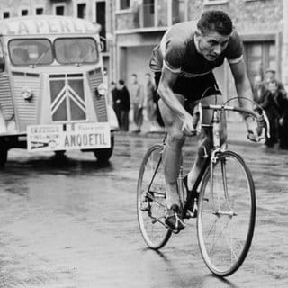 Radrennfahrer Jacques Anquetil auf dem Rad, angefeuert von den Zuschauern, beim Grand Prix des Nations 1954.