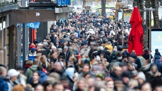 Symbolbild: Menschen laufen in Stuttgart die Königstraße entlang. Die Aufnahme ist mit Langzeitbelichtung entstanden.