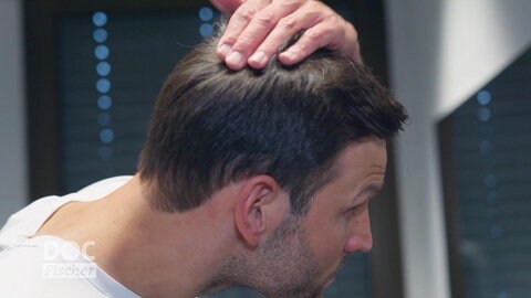 Ein Mann fährt sich durch seine Haare