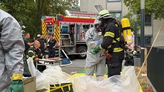 Feuerwehrleute legen Schutzanzüge an: In Mainz wird für einen Notfall mit radioaktiven Stoffen geübt