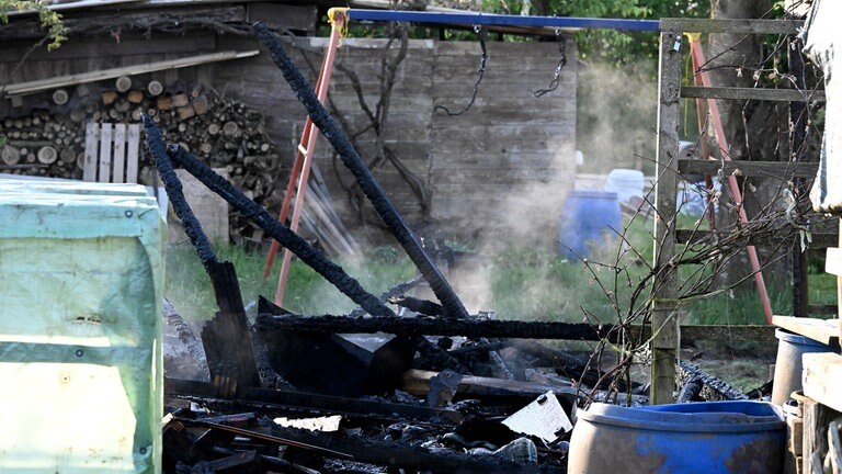 Rauch und Schutt in einem Schrebergarten. Die Schaukel ist noch zu erkennen, ansonsten ist wenig heil gebliben bei den Bränden in der Kleingartenanlage in Langenau.
