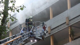 Feuerwehr auf Drehleiter bei Brand in Mehrfamilienhaus