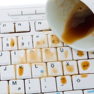Symbolbild: Kaffeetasse ausgeschüttet auf Tastatur eines Computers