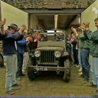 Klatschende Männer stehen Spalier für einen Jeep beim Guinness-Weltrekord in Gevenich