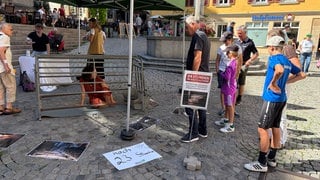 Eine Aktivistin sitzt in einem Schweinekäfig in der Tübinger Altstadt