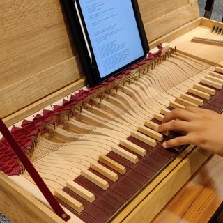 Hände die auf einem Clavichord spielen